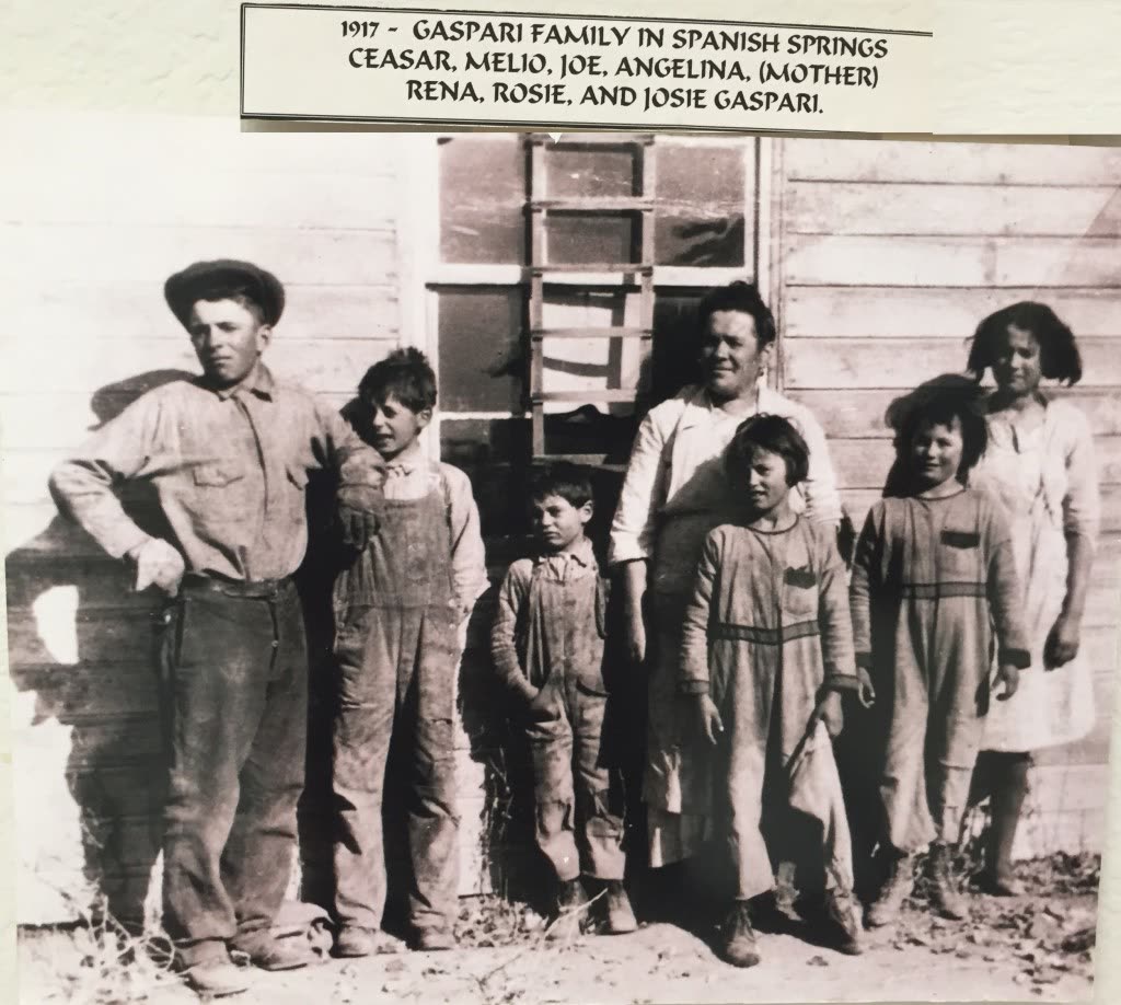 Black and white 1917 photo of the Gaspari family standing in front of a wooden farmhouse in Spanish Springs