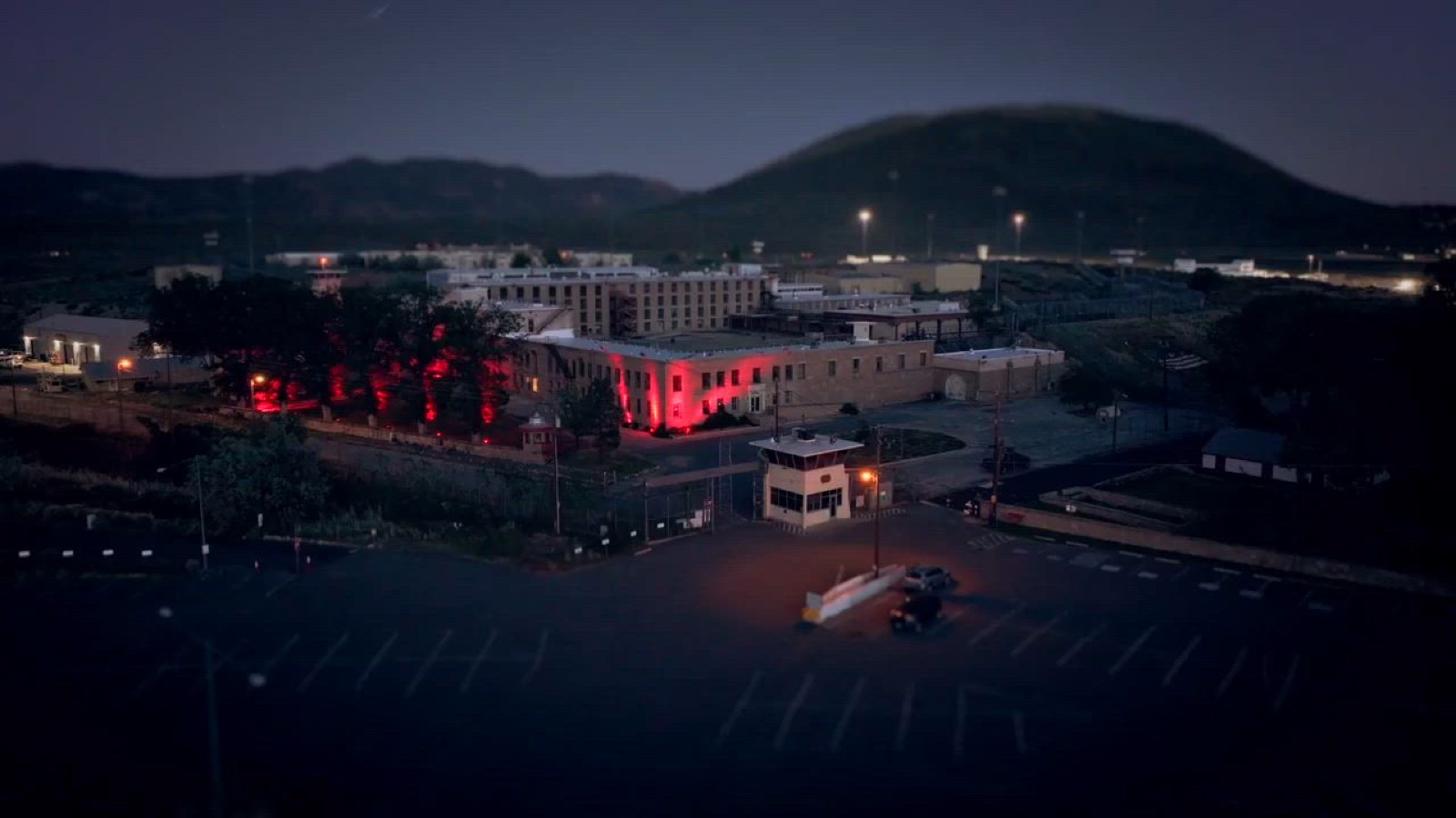 Aerial view of the former Nevada State Prison at dusk, lit in red for Dark Prison